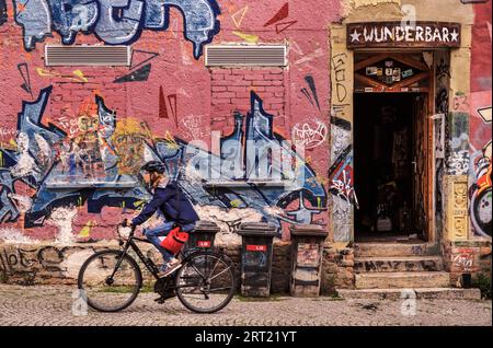 The cyclist in front of the colourful graffiti wall Stock Photo