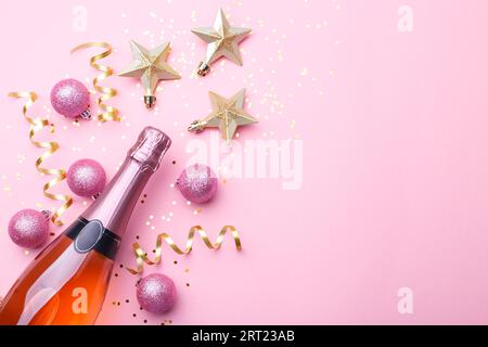 Flat lay composition of Champagne bottle golden Christmas decorations on trendy pink background copy space Stock Photo