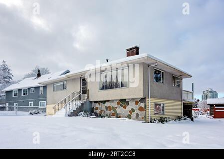 Average residential houses in snow on overcast sky background Stock Photo