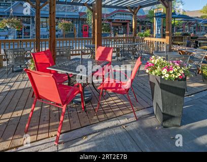 Canmore, Alberta, Canada – September 09, 2023:  Red chairs at an outdoor dining patio in downtown Stock Photo