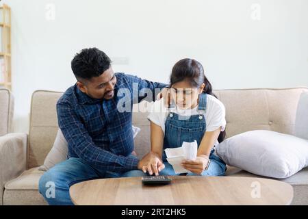 husband comforting stress wife sit on couch read financial papers invoices troubled with too high expenses utility Stock Photo