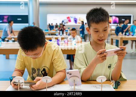 CHONGQING, CHINA - SEPTEMBER 10, 2023 - People experience Apple products at an Apple store on Jiefangbei Pedestrian Street in Chongqing, China, Sept. Stock Photo