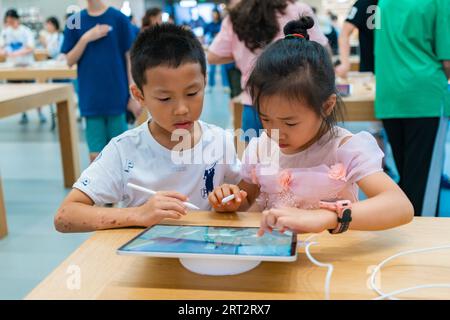 CHONGQING, CHINA - SEPTEMBER 10, 2023 - People experience Apple products at an Apple store on Jiefangbei Pedestrian Street in Chongqing, China, Sept. Stock Photo