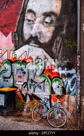 The bicycle, parked in front of the graffiti wall Stock Photo