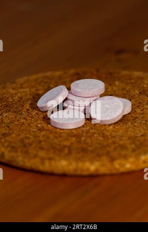 Several vitamins are placed on a cork circle. Stock Photo