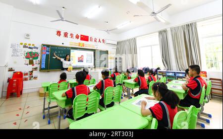(230910) -- HAIKOU, Sept. 10, 2023 (Xinhua) -- Fu Yaohui gives a class at Hainan (Haikou) Special School in Haikou, south China's Hainan Province, Sept. 6, 2023. Fu Yaohui is a teacher at the special education school in Haikou. Since 2004, Fu has been engaged in special education for students with intellectual disabilities, cultivating their basic skills to adapt to life. Every day, Fu arrives at school early and accompanies the students with patience and encouragement. 'I want my students to be self-reliant,' she said. In order to achieve this goal, she tries her best to help these children Stock Photo