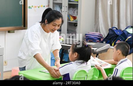 (230910) -- HAIKOU, Sept. 10, 2023 (Xinhua) -- Fu Yaohui gives a class at Hainan (Haikou) Special School in Haikou, south China's Hainan Province, Sept. 5, 2023. Fu Yaohui is a teacher at the special education school in Haikou. Since 2004, Fu has been engaged in special education for students with intellectual disabilities, cultivating their basic skills to adapt to life. Every day, Fu arrives at school early and accompanies the students with patience and encouragement. 'I want my students to be self-reliant,' she said. In order to achieve this goal, she tries her best to help these children Stock Photo