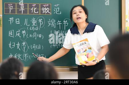 (230910) -- HAIKOU, Sept. 10, 2023 (Xinhua) -- Fu Yaohui gives a class at Hainan (Haikou) Special School in Haikou, south China's Hainan Province, Sept. 6, 2023. Fu Yaohui is a teacher at the special education school in Haikou. Since 2004, Fu has been engaged in special education for students with intellectual disabilities, cultivating their basic skills to adapt to life. Every day, Fu arrives at school early and accompanies the students with patience and encouragement. 'I want my students to be self-reliant,' she said. In order to achieve this goal, she tries her best to help these children Stock Photo