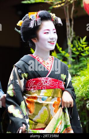 Kyoto, Japan, May 14 2019: Portrait of a young Maiko Geisha who is being led to houses of clientele by her guide in Gion district of Kyoto, Japan Stock Photo