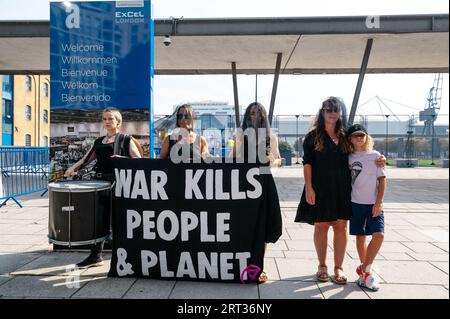 London, UK. 10 September 2023. Extinction Rebellion activists demonstrate outside the entrance to the DSEI exhibition at the ExCel centre in London. The protesters laid child shoes in front of a banner saying “war kills people & planet”. Credit: Andrea Domeniconi/Alamy Live News Stock Photo