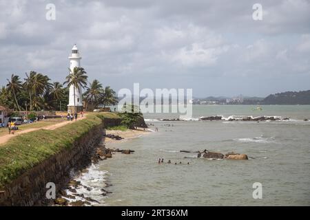 Galle Fort, Sri Lanka, July 27, 2018: The lighthouse and people walking on the fort wall Stock Photo