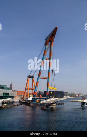Copenhagen, Denmark, April 4, 2019: The huge Floating Crane Hebo Lift 9 installing parts for a new cycling bridge over the harbour Stock Photo