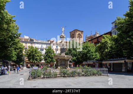 Granada, Spain, May 27, 2019: People walking past a fountain on Bib Rambla Square in the historic city centre Stock Photo