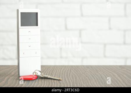 House remote controller with display and metallic keys from the door. Home access and security concept Stock Photo