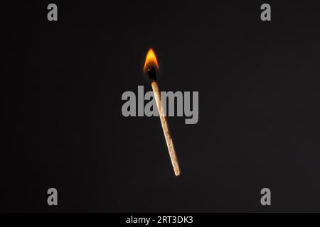 Lit and falling match on a black background. Stock Photo