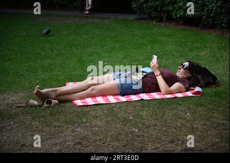 London, UK. 10th Sep, 2023. People in London take shelter under the tree at Harbour Quay Gardens, Canary Wharf, London, UK due to the hot weather. Credit: See Li/Picture Capital/Alamy Live News Stock Photo