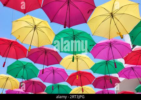 Hanging colorful umbrellas against the blue sky. Stock Photo