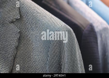 Racks with different men's suits in a men's clothing boutique. Stock Photo