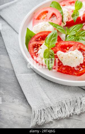 Vibrant Caprese Salad Displayed on White Plate with Soft Gray Napkin Stock Photo