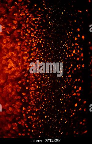 Background of blurred raindrops on glass at night in orange light. Abstract blurred background Stock Photo