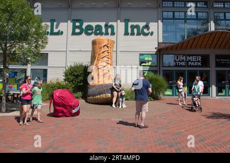 Tourists and shoppers pose with the duck boot outside of the LL Bean Retail Store, Freeport, Maine, USA Stock Photo