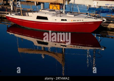 Red and white boat reflected in the harbor, Port Townsend, Washington Stock Photo