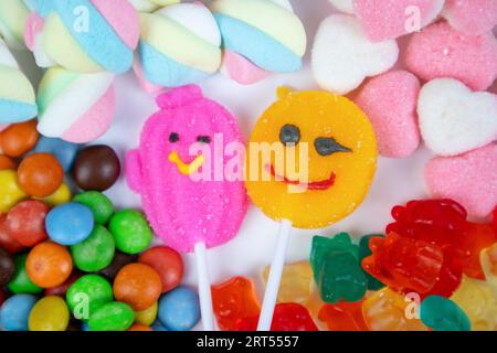 piles of various kinds of sweets and candies with a focus on the smiling candy Stock Photo