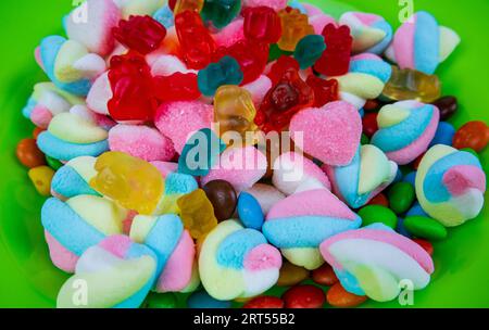 piles of various kinds of sweets and candies. Milk chocolate candy and jelly gum. Stock Photo