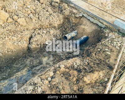 sandy ditch with communications. in a new microdistrict of the city, pipes are being laid to bring communications to residential buildings. draining w Stock Photo