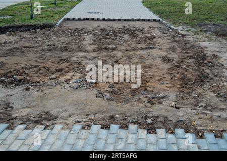 an asphalt road was destroyed in the city. dismantled asphalt. concrete bricks must be repositioned. the ground is visible from under the cover. layin Stock Photo