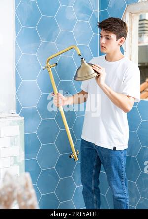 Guy preparing new shower for installation in building under construction Stock Photo