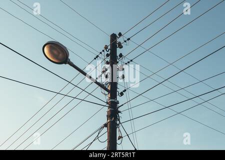Street light with electricity utility pole and electrical wires, low angle view Stock Photo