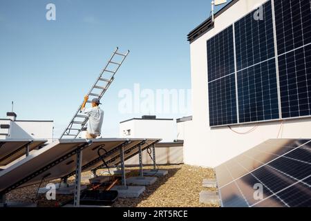 Man carries ladder during solar panels installation Stock Photo