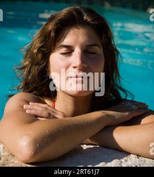 Woman relaxes in a pool with eyes closed. Stock Photo