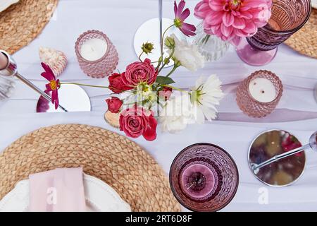 Table setting graced by candles and flowers arrangement. The wedding embodies the aesthetics of Provence. Stock Photo