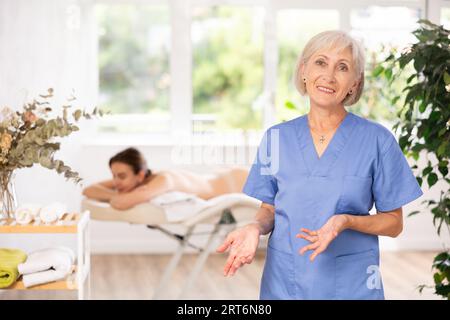 Elderly woman masseuse posing in spa salon Stock Photo