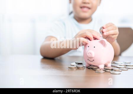 A little girl saving money in piggy bank Stock Photo