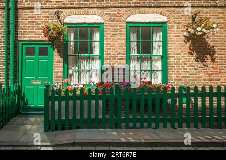 Victorian terraced brick town cottage front with garden flowes. Stock Photo
