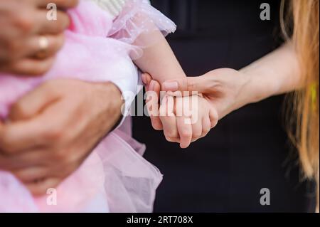 A woman holds a child's hand. Hands of a girl and a baby Stock Photo