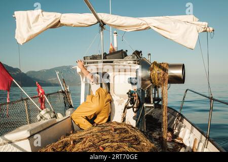 Floating boat with unrecognizable fisherman in rippling seawater - a  Royalty Free Stock Photo from Photocase