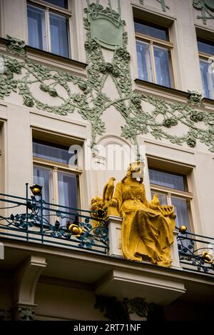 Earthy colors of an Art Nouveau facade with Princess Libuse sculpture in the heart of Prague, Czech Republic, a medieval wise literary figure. Stock Photo