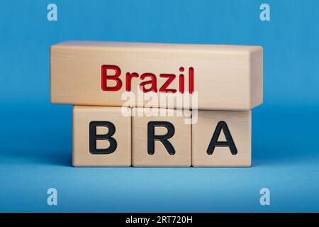Brazil and BRA symbol. Concept words Brazil and BRA on wooden blocks.  English name and abbreviation of country name. Copy space.3D rendering on blue Stock Photo