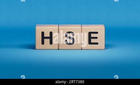 HSE Health Safety Environment acronym on wooden cubes.3D rendering on blue background. Stock Photo