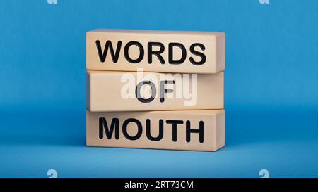 Words of mouth symbol. Concept words Words of mouth on wooden blocks. Business, finacial and words of mouth concept. Copy space.3D rendering on blue b Stock Photo