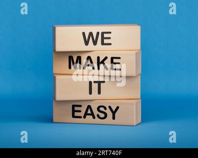 We make it easy symbol. Concept words We make it easy on wooden cubes.Businessman hand. Business motivational we make it easy concept. Copy space.3D r Stock Photo