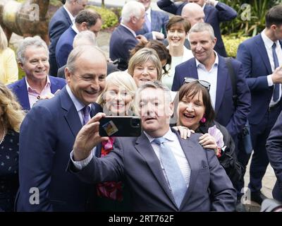 Tanaiste Micheal Martin (centre) having a selfie with Billy Kelleher before a Fianna Fail party event at the Horse and Jockey Hotel in Thurles, Co. Tipperary. Picture date: Monday September 11, 2023. Stock Photo