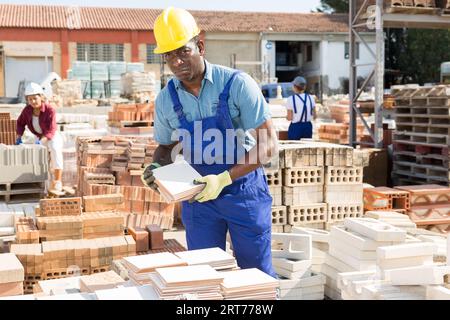 Builder is choosing ceramic tiles in building store Stock Photo