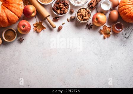 Autumn fall baking background with pumpkins, apples, nuts, food ingredients and seasonal spices. Cooking pumpkin or apple pie and cookies for Thanksgi Stock Photo