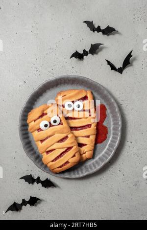 Halloween shortbread cookies with strawberry jam. Cookie is a mummy with eyes Stock Photo