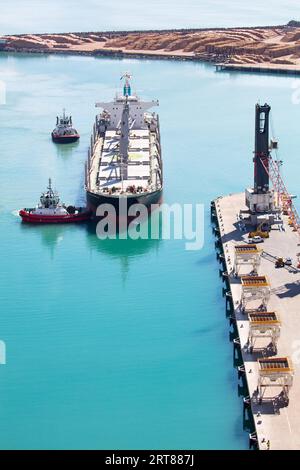 NAPIER, NEW ZEALAND -SEPTEMBER 30, 2017: Tug boats guide a shipping container into the Port of Napier in New Zealand Stock Photo